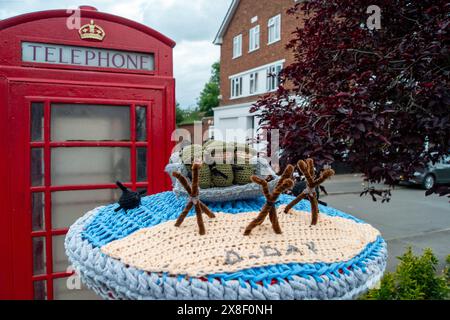 Eton Wick, Regno Unito. 25 maggio 2024. Un contenitore postale a maglia del D-Day Anniversary Post Topper nel villaggio di Eton Wick, Windsor, Berkshire. La Royal British Legion celebrerà il 80° anniversario del D-D nel Regno Unito e in Normandia il 5 e 6 giugno 2024, nonché gli eventi della comunità in tutto il Regno Unito. Chiedono ai veterani della Normandia, alle famiglie dei caduti, ai discendenti dei veterani della Normandia e ai membri del pubblico di unirsi a loro per commemorare il D-Day 80. Crediti: Maureen McLean/Alamy Live News Foto Stock