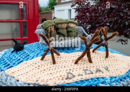 Eton Wick, Regno Unito. 25 maggio 2024. Un contenitore postale a maglia del D-Day Anniversary Post Topper nel villaggio di Eton Wick, Windsor, Berkshire. La Royal British Legion celebrerà il 80° anniversario del D-D nel Regno Unito e in Normandia il 5 e 6 giugno 2024, nonché gli eventi della comunità in tutto il Regno Unito. Chiedono ai veterani della Normandia, alle famiglie dei caduti, ai discendenti dei veterani della Normandia e ai membri del pubblico di unirsi a loro per commemorare il D-Day 80. Crediti: Maureen McLean/Alamy Live News Foto Stock