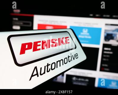 Smartphone con logo della concessionaria americana Penske Automotive Group Inc. Davanti al sito Web. Mettere a fuoco la parte centrale sinistra del display del telefono. Foto Stock