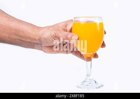 tenere a mano un bicchiere di succo d'arancia o di mango isolato su sfondo bianco con percorso di ritaglio Foto Stock