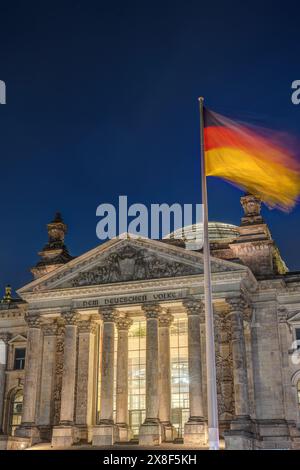 Il portale d'ingresso del Reichstag di Berlino con la bandiera tedesca di notte Foto Stock