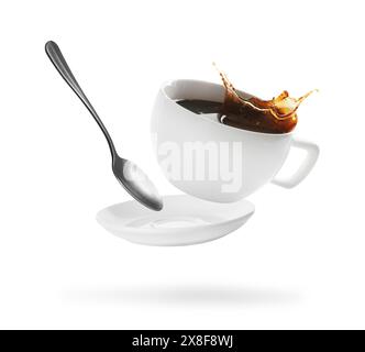 Tazza di caffè, piattino e cucchiaio in aria su sfondo bianco Foto Stock