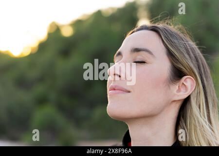 Primo piano ritratto di una donna che respira aria fresca. Pace interiore Foto Stock