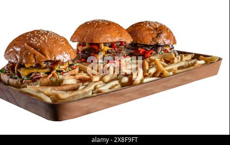 Tre classici cheeseburger con patatine fritte da tavolo in legno. Formaggio, pomodori, cipolle. Lattuga, senape e ketchup isolati su sfondo bianco. Fresco Foto Stock