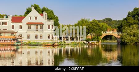 Panorama di una casa e di un ponte nel giardino di Quyuan sul lago occidentale di Hangzhou, Cina Foto Stock