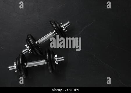 Campanelli su pavimento con texture scure, vista dall'alto. Spazio per il testo Foto Stock