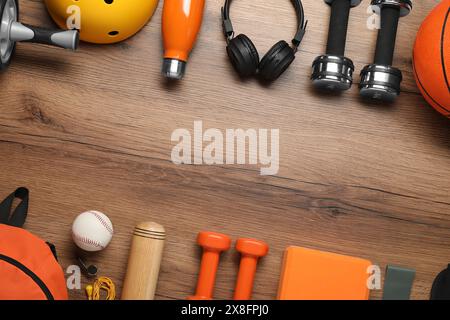 Telaio realizzato con diverse attrezzature sportive su un tavolo in legno, piano. Spazio per il testo Foto Stock