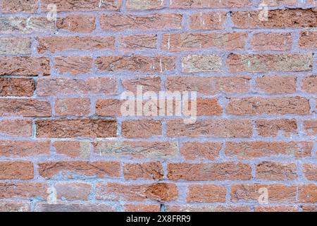 Vecchio muro in mattoni rossi con un sacco di texture e colori. Modello astratto di una vecchia parete di mattoni rossi, arancioni e neri, con molta consistenza utile per lo sfondo Foto Stock