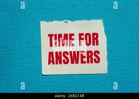 Tempo per le risposte parole scritte su carta strappata con sfondo blu. Simbolo tempo concettuale per le risposte. Copia spazio. Foto Stock