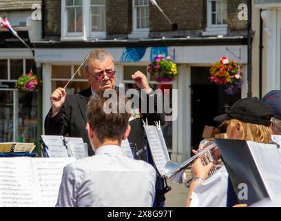 La Silver band suona in strada al Framlingham Market Hill & Market Day condotto da un uomo di mezza età con un bastone che sembra tutt'altro che felice Foto Stock