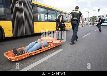 Berlino, Germania. 25 maggio 2024. La polizia usa una slitta per l'arresto di un manifestante troppo pesante da sollevare come sostenitori e attivisti del gruppo di attivisti per il clima "Letzte Generation" (ultima generazione) ha creato un blocco stradale di disobbedienza civile su Rahel-Hirsch-Strasse vicino a Washingtonplatz di fronte alla stazione ferroviaria centrale di Berlino. (Credit Image: © Michael Kuenne/PRESSCOV via ZUMA Press Wire) SOLO PER USO EDITORIALE! Non per USO commerciale! Crediti: ZUMA Press, Inc./Alamy Live News Foto Stock