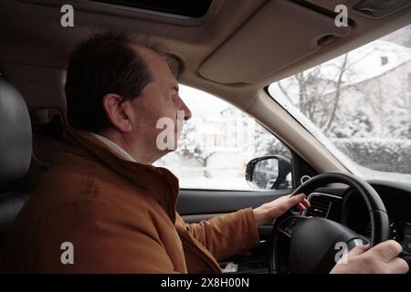 Un uomo guida un'auto per la città. Vista dall'interno della vettura. Primo piano. Foto Stock
