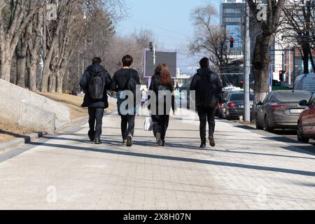 Quattro amici camminano per strada. Pushkin Street. Chisinau, Repubblica di Moldavia. 23 febbraio 2021, alle 17.13,41. Foto Stock