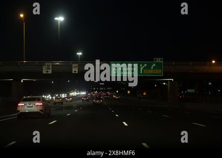 Autostrada notturna con veicoli in movimento illuminati da semafori - indicazioni stradali per Steeles Ave e Woodbine Avenue. Presa a Toronto, Canad Foto Stock