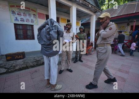 Anantnag, Jammu e Kashmir, India. 25 maggio 2024. I soldati paramilitari decollano pehran (un tessuto tradizionale) di un vecchio uomo Kashmiri prima di votare in una stazione elettorale, durante la sesta fase elettorale, ad Anantnag, a circa 70 km da Srinagar. (Credit Image: © Mubashir Hassan/Pacific Press via ZUMA Press Wire) SOLO PER USO EDITORIALE! Non per USO commerciale! Foto Stock