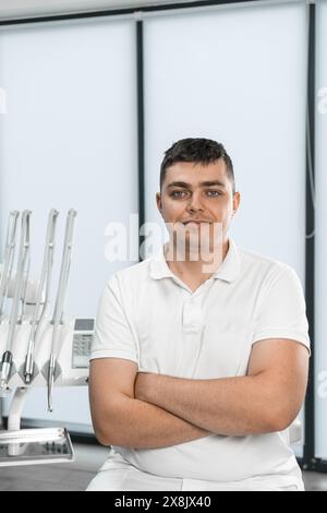 Un dentista di sesso maschile gestisce il suo studio odontoiatrico con le proprie mani, fornendo un ambiente confortevole per i pazienti. Foto Stock