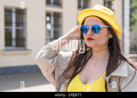 Slancio per i viaggi: La donna in giallo sente che il mondo la aspetta. In attesa dell'incredibile: Si apre uno spazio infinito di possibilità Foto Stock