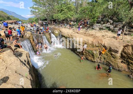 Dolores, Filippine. 25 maggio 2024: I filippini affollano torrenti che non si sono prosciugati per sfuggire al caldo soffocante delle città. A Calabarzon, alcuni trovano rifugio a Paeng Falls, una nuova destinazione creata dal tifone Paeng (2022). In streaming dal Monte Banahaw, una montagna sacra soggetta a frane, erosione e alluvioni distruttive, il letto del fiume Lagnas si è placato per formare queste cascate molto apprezzate in quanto l'arcipelago e il sud-est asiatico soffrono di forti ondate di caldo e siccità a causa di El Nino che terminerà con la depressione tropicale Aghon, la prima tempesta a colpire il paese quest'anno. Crediti: Kevin Izorce/Alamy Live News Foto Stock