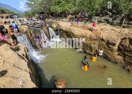Dolores, Filippine. 25 maggio 2024: I filippini affollano torrenti che non si sono prosciugati per sfuggire al caldo soffocante delle città. A Calabarzon, alcuni trovano rifugio a Paeng Falls, una nuova destinazione creata dal tifone Paeng (2022). In streaming dal Monte Banahaw, una montagna sacra soggetta a frane, erosione e alluvioni distruttive, il letto del fiume Lagnas si è placato per formare queste cascate molto apprezzate in quanto l'arcipelago e il sud-est asiatico soffrono di forti ondate di caldo e siccità a causa di El Nino che terminerà con la depressione tropicale Aghon, la prima tempesta a colpire il paese quest'anno. Crediti: Kevin Izorce/Alamy Live News Foto Stock