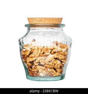 Metà del nocciolo di noce, in vaso di vetro isolato su sfondo bianco. Semi secchi e sgusciati del comune noce Juglans regia, utilizzati come snack o per ba Foto Stock