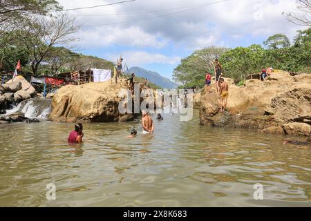 Dolores, Filippine. 25 maggio 2024: I filippini affollano torrenti che non si sono prosciugati per sfuggire al caldo soffocante delle città. A Calabarzon, alcuni trovano rifugio a Paeng Falls, una nuova destinazione creata dal tifone Paeng (2022). In streaming dal Monte Banahaw, una montagna sacra soggetta a frane, erosione e alluvioni distruttive, il letto del fiume Lagnas si è placato per formare queste cascate molto apprezzate in quanto l'arcipelago e il sud-est asiatico soffrono di forti ondate di caldo e siccità a causa di El Nino che terminerà con la depressione tropicale Aghon, la prima tempesta a colpire il paese quest'anno. Crediti: Kevin Izorce/Alamy Live News Foto Stock