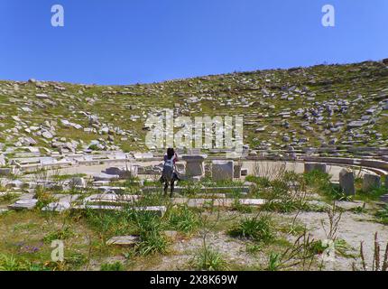 Viaggiatore donna che visita l'antico teatro di Delo, incredibile sito archeologico sull'isola di Delo, Mykonos, Grecia Foto Stock