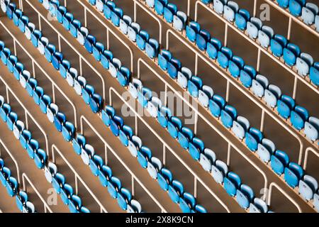 Vista dall'alto dei posti vuoti dello stadio disposti in file ordinate. I posti a sedere sono di colore blu chiaro e blu scuro. Foto Stock