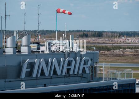 Helsinki / Finlandia - 4 APRILE 2024: Logo della compagnia di bandiera finlandese Finnair sul muro di un edificio. Aeroporto Helsinki-Vantaa sullo sfondo. Foto Stock