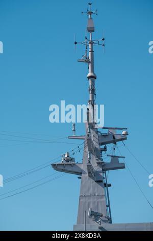 Helsinki / Finlandia - 5 APRILE 2024: Primo piano di un albero e delle antenne su una nave da guerra si aggrava su un cielo blu brillante. Foto Stock