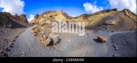 Vista panoramica del sentiero escursionistico attraverso il gigantesco cratere vulcanico del vulcano El cuervo, Lanzarote, Isole Canarie, Spagna Foto Stock