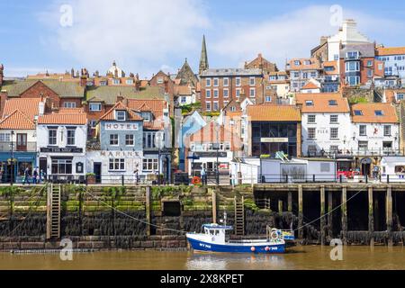 Whitby Yorkshire Whitby Harbour con una piccola barca da pesca nel porto e il mercato ittico sul molo Whitby North Yorkshire Inghilterra Regno Unito Europa Foto Stock