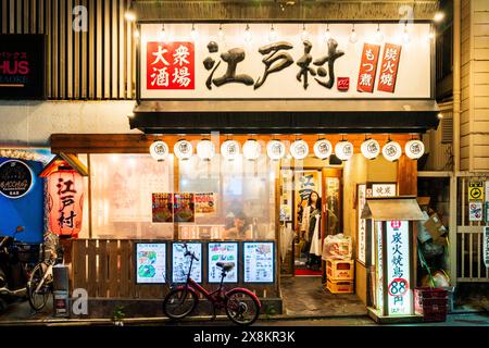 Esterno di un tipico bar giapponese Izakaya, cibo e bevande. Lanterne bianche Chochin, porta aperta e finestre rivestite con carta bianca per una maggiore privacy. Foto Stock