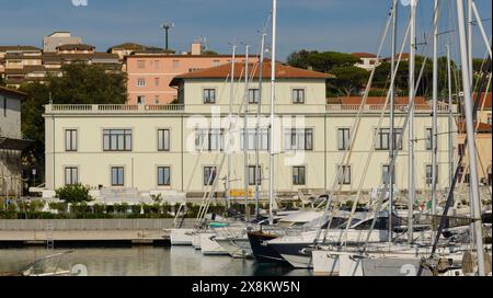 Municipio visto dal porto turistico di San Vincenzo, con barche a vela e motoscafi ormeggiati. San Vincenzo, Toscana, Italia Foto Stock