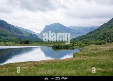 Lake District National Park, Cumbria, Inghilterra. Vista sulla tranquilla superficie di Crummock Water fino alla cima di Fleetwith Pike. Foto Stock