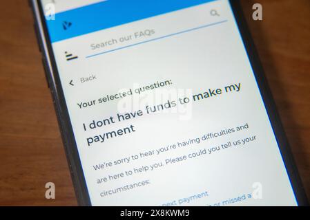 Schermata del telefono cellulare che visualizza una pagina delle domande frequenti sui fondi insufficienti per il pagamento, evidenziando le difficoltà finanziarie e le opzioni di assistenza Foto Stock