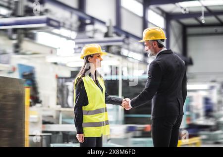 Responsabile del magazzino donna che parla con il dipendente della logistica nel magazzino, pianifica il trasporto di prodotti, merci, parla del processo di spedizione. Foto Stock