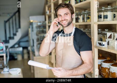 Bell'uomo che lavora in un negozio senza imballaggio utilizzando contenitori riutilizzabili. Zero negozi di rifiuti che offrono prodotti sfusi senza imballaggio e alternative sostenibili. Foto Stock