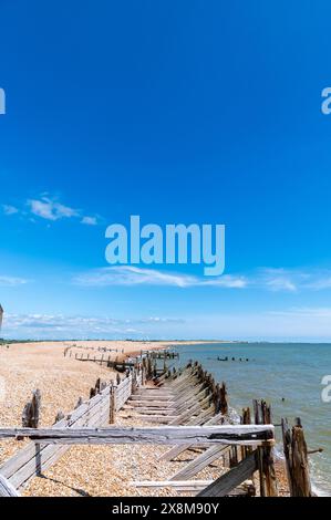 Il cielo azzurro e profondo sopra le difese marine della riserva naturale Rye Harbour, in Inghilterra, con alcune nuvole bianche, prospettiva e orizzonte. Foto Stock