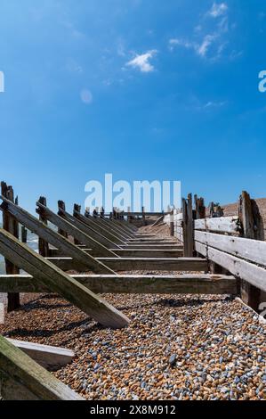 Il cielo azzurro e profondo sopra le difese marine della riserva naturale Rye Harbour, in Inghilterra, con alcune nuvole bianche, prospettiva e orizzonte. Foto Stock