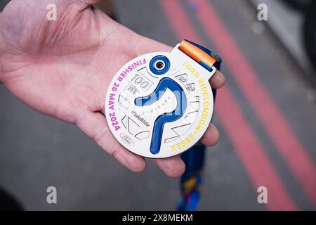 Londra, Regno Unito. 26 maggio 2024. Un partecipante detiene una medaglia di risultato durante l'evento. Ford RideLondon 2024, uno dei più grandi eventi ciclistici di Londra, si svolge questo fine settimana. I ciclisti inizieranno nel centro di Londra e viaggeranno attraverso l'Essex prima di tornare al traguardo al Tower Bridge. Credito: SOPA Images Limited/Alamy Live News Foto Stock