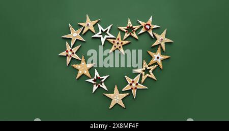Biscotti di Natale fatti a mano a forma di stella, decorati con ornamenti, con glassa e frutti di bosco. Forma del cuore Foto Stock