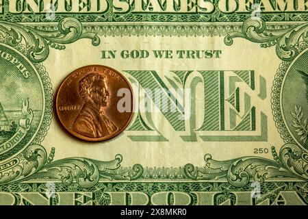 Dettaglio di una banconota da un dollaro con una moneta di Abraham Lincoln sopra la "o" in "uno" e la frase "in Dio ci fidiamo" Foto Stock