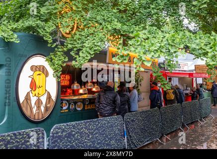 Persone in coda per un pranzo di pollo all'esterno di un furgone alimentare mobile in occasione di un evento Foto Stock