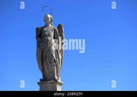 Colonna di marmo con statua dell'Arcangelo sulla sommità. Trionfo di San Rafael de la Puerta del Puente dedicato all'angelo custode di Cordova, Spagna Foto Stock