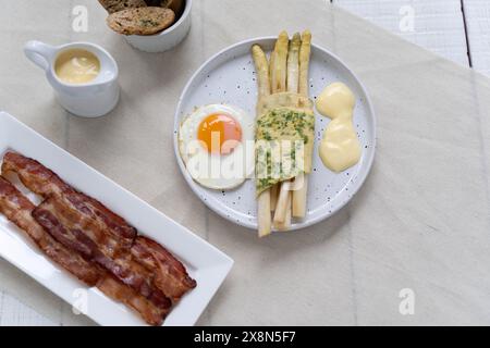 Asparagi bianchi serviti con uova fritte. Gli asparagi sono molto popolari in Germania durante Spargelzeit, che rappresenta una fonte di fibre alimentari Foto Stock
