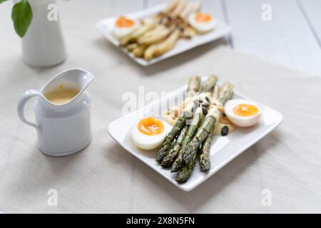 Asparagi verdi e bianchi serviti con uova sode. Gli asparagi sono molto popolari in Germania durante Spargelzeit, che rappresenta una fonte di fibre alimentari Foto Stock