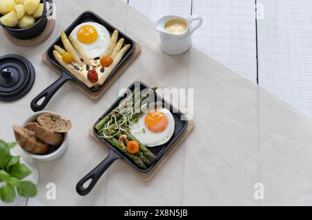 Asparagi verdi e bianchi serviti con pomodori, uova fritte, patate bollite. Questo piatto di stagione è molto popolare in Germania durante lo Spargelzeit Foto Stock