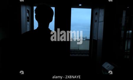 Giovane che guarda attraverso la finestra del treno passeggeri. Fermo di scorta. Uomo nei trasporti pubblici. Foto Stock