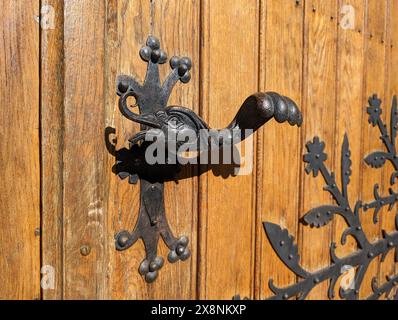Primo piano della maniglia della portiera vintage retrò. Vecchia porta in legno con bellissimi pomelli retrò a forma di testa e ala di anatre. Messa a fuoco selettiva. Foto Stock