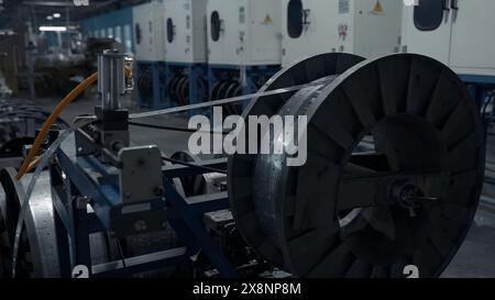 Primo piano della bobina grande a rotazione lenta con l'avvolgimento di lamiere sottili. Creatività. Background industriale nello stabilimento. Foto Stock